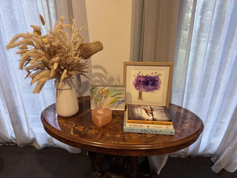 Warm reflective counselling room details with books, candle and flowers